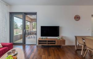 uma sala de estar com uma televisão e uma mesa em SPADA Apartment 3 bedrooms near the beach! em Porec