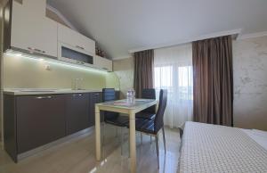 a room with a table and a kitchen and a bed at Guesthouse Phoenix in Obzor