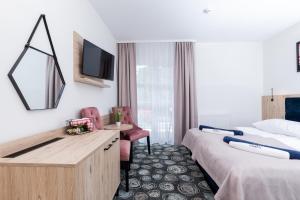 a hotel room with two beds and a desk at Villa Solaris in Pobierowo
