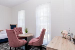 a bedroom with a table and two chairs and a bed at Villa Solaris in Pobierowo