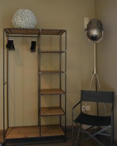 a shelf in a room with a lamp and a chair at Maison du chien vert in Corbion