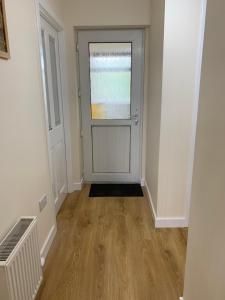 an empty hallway with a door and a window at Greenfield Cottage in Thrumster