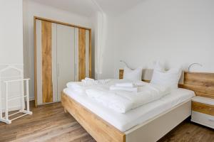 a bedroom with a large white bed with white pillows at Villa Zeitlos in Börgerende-Rethwisch