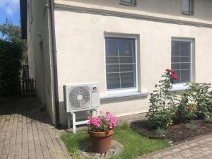 a house with a fan in front of a house at Butas Prie Kaštono in Nida