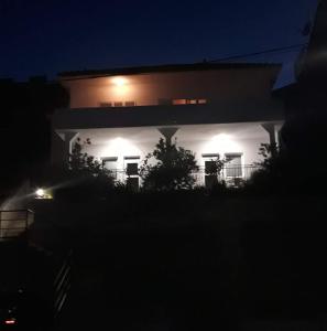 une maison éclairée la nuit avec des lumières dans l'établissement Apartmani Skalinada, à Marina
