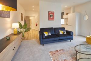 Il comprend un salon avec un canapé bleu et une cuisine. dans l'établissement Host & Stay - Cornerhouse Apartments, à Saltburn-by-the-Sea