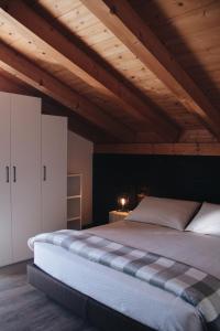 a large bed in a room with wooden ceilings at SAN ROMEDIO Agriturismo in Romeno