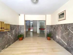 Casa Gordigiani - bilocali con parcheggio في فلورنسا: ممر فارغ في مبنى به نباتات الفخار