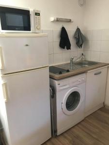 a kitchen with a washing machine and a microwave at L'échoppe Rochelaise in La Rochelle