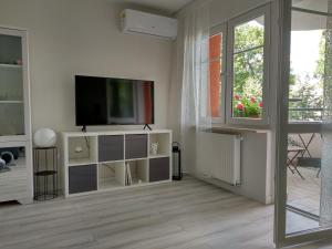 a white living room with a tv and a window at RiC Apart - Apartament Mostowa, centrum Poznań - parking - klimatyzacja in Poznań