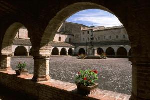 an archway in a building with flowers in a courtyard at Locanda Le Logge in Urbisaglia