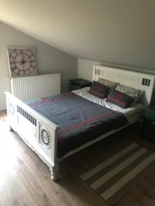 a large bed in a bedroom with a clock on the wall at Siedlisko U Źródeł in Skierbieszów