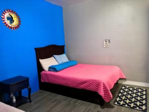 a bedroom with a bed with a pink and blue blanket at MonteAlbán house in Oaxaca City