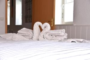 2 cygnes de serviettes assises au-dessus d'un lit dans l'établissement FeWo 1 - Deidesheim, à Deidesheim
