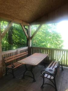 a porch with a wooden table and benches on it at Siedlisko U Źródeł in Skierbieszów