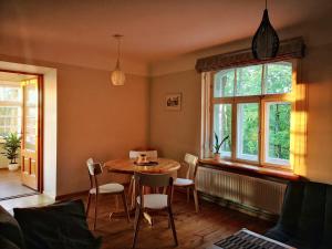 uma sala de jantar com uma mesa e cadeiras e uma janela em Castle Park Apartment with sunset veranda em Cēsis