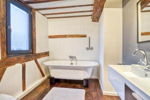 La salle de bains est pourvue d'une baignoire et d'un lavabo. dans l'établissement Chez Mamy, à Liège