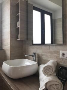 La salle de bains est pourvue d'une baignoire, d'un miroir et de serviettes. dans l'établissement Bella Posada B&B, à Buggerru