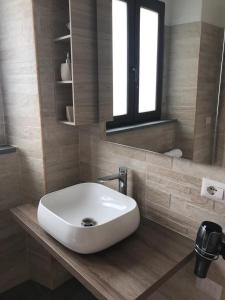 uma casa de banho com um lavatório branco e um espelho. em Bella Posada B&B em Buggerru
