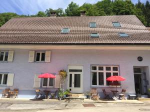 een huis met stoelen en rode parasols ervoor bij Bed and Breakfast 57 in Asuel