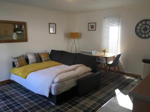1 dormitorio con 1 cama grande y 1 mesa en Tigh Stobban Apartment 1, en Fort William