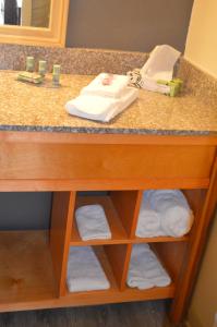 a bathroom sink with a vanity with towels on it at Lake View Inn in Granbury