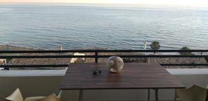 a table on a balcony with a view of the ocean at Glyfada Home 113 by New Era in Menigos Resort Apartments in Glyfada