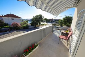 een patio met een tafel en een stoel op een balkon bij Pavle's Apartment in Zadar