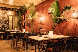 a restaurant with tables and chairs and plants on the wall at Hotel Aiguaclara in Begur