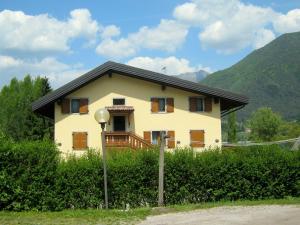 una pequeña casa amarilla con techo negro en Luxurious Apartment in Gosau near Ski Area, en Molina di Ledro