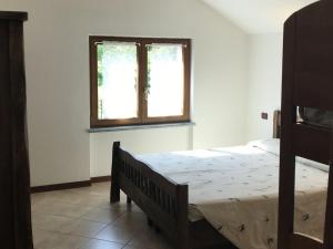 1 dormitorio con cama y ventana en Luxurious Apartment in Gosau near Ski Area, en Molina di Ledro