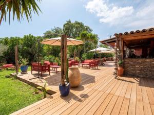 ポッジョ・メッザナにあるCharming Villa in Poggio Mezzana on the Beachsideの木製デッキ(テーブル、傘付)