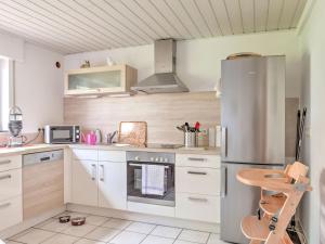 a kitchen with white cabinets and a stainless steel refrigerator at Sunny flat in Bad Driburg with garden in Bad Driburg