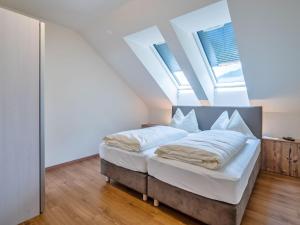 um quarto com uma cama com lençóis brancos em Warm Apartment in Gosau with shared Sauna em Gosau