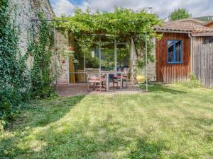 um pátio com uma mesa e cadeiras num quintal em Cosy holiday home with garden em Ponet-et-Saint-Auban