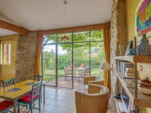 een eetkamer met een tafel en stoelen en een groot raam bij Cosy holiday home with garden in Ponet-et-Saint-Auban