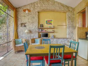 uma cozinha e sala de jantar com mesa e cadeiras em Cosy holiday home with garden em Ponet-et-Saint-Auban