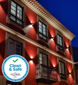 a red building with a sign that says clean and safe at Memória Boutique Hostel in Angra do Heroísmo