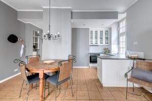 eine Küche und ein Esszimmer mit einem Holztisch und Stühlen in der Unterkunft Mariacka Apartment Old Town Gdansk in Danzig