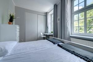Schlafzimmer mit einem großen weißen Bett und einem Fenster in der Unterkunft Mariacka Apartment Old Town Gdansk in Danzig