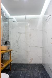 een badkamer met een glazen douche en een wastafel bij Laura maisons in Kalamata