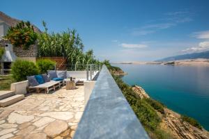 a patio with a view of a body of water at A White Cliffside Studio in Pag