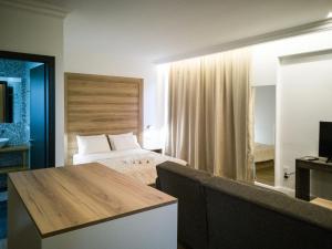 pokój hotelowy z łóżkiem i telewizorem w obiekcie Laura maisons w Kalamácie