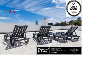 two black rocking chairs sitting on a patio at Arquinha Apartment in Ponta Delgada