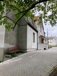 a bench sitting next to a building next to a street at Joyful Apartments Sopot in Sopot