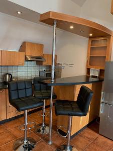 a kitchen with black bar stools and a counter at Apartament Ustronie Leśne in Międzyzdroje