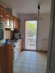 a kitchen with a door leading to a patio at MAISON AU COEUR DE LA PETITE CITE DE CARACTERE in Malestroit