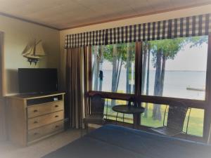 a bedroom with a large window with a view of the water at Square Rigger Harbor Motel in Baileys Harbor