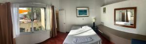 a small room with a bed and a window at Palmira Hostel in Tegucigalpa
