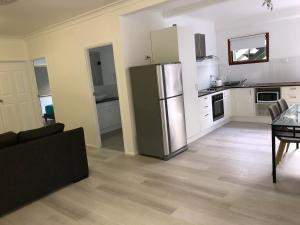 a kitchen with a stainless steel refrigerator in a room at Airlie Getaway Unit 3 in Cannonvale